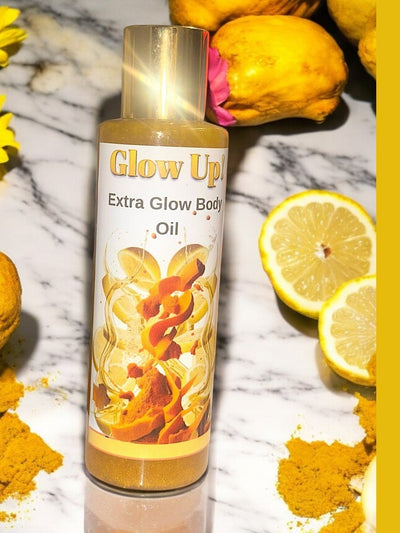 Glow Up Extra Glow Body Oil in a bottle on a marble surface with lemon and flowers