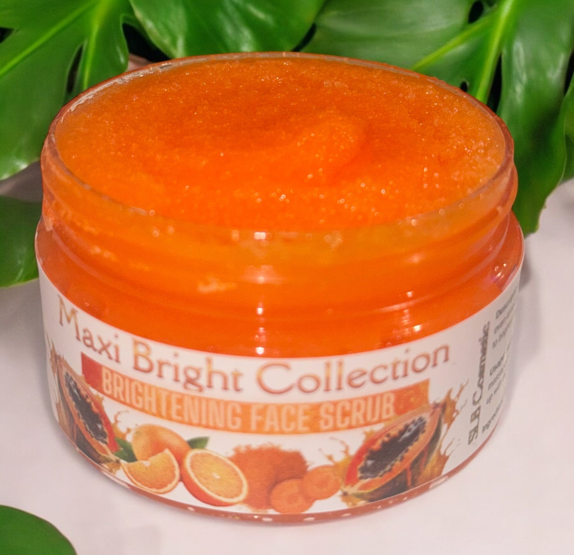 Maxi brightening skincare kit featuring a brightening face scrub with vibrant orange texture